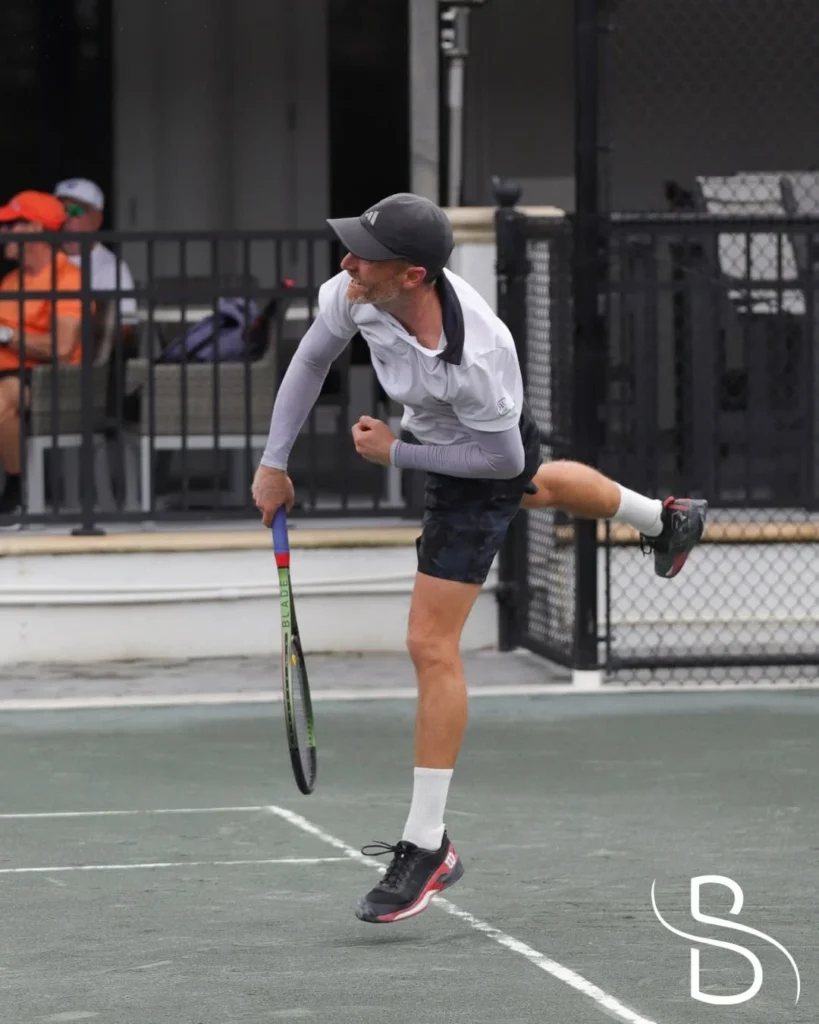 Player serving during a tennis match at Broken Sound Club in Boca Raton