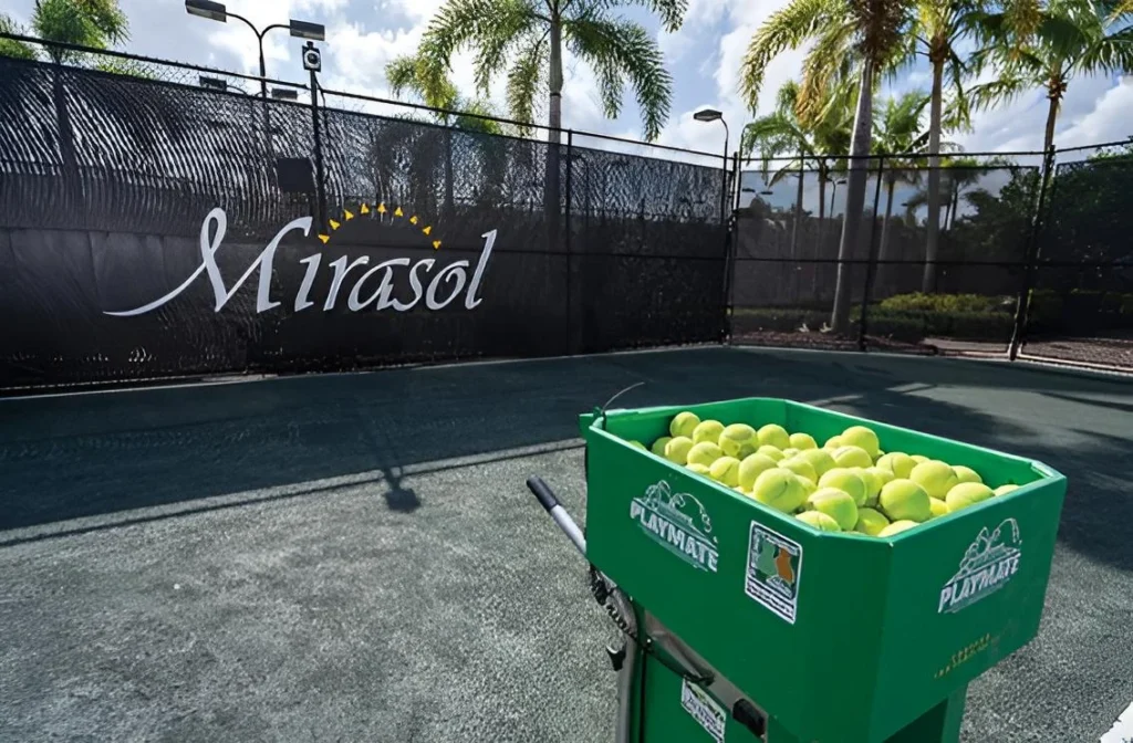 Ball machine and tennis balls on a Har-Tru tennis court at The Club at Mirasol in Palm Beach Gardens Florida