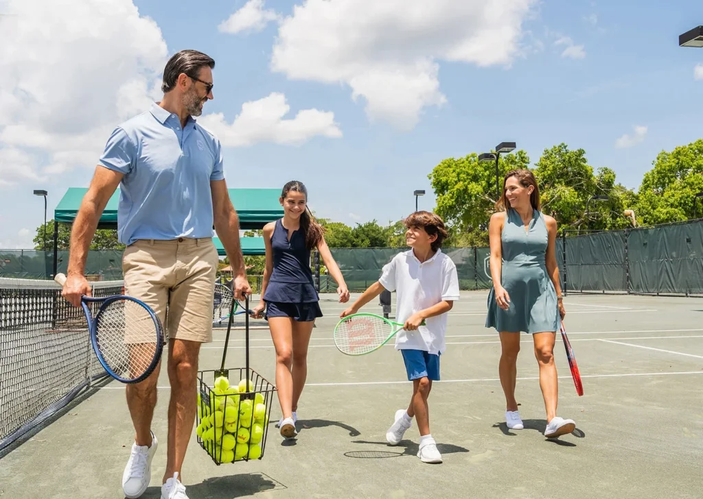 Family walking onto the tennis courts at PGA National Sports & Racquet Club