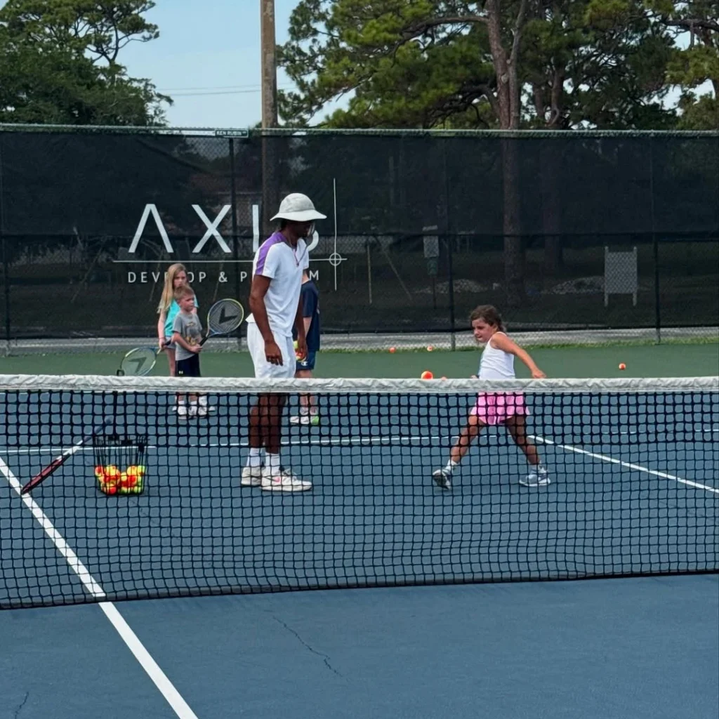 Tennis coach leading a junior development session at Axis Tennis Academy
