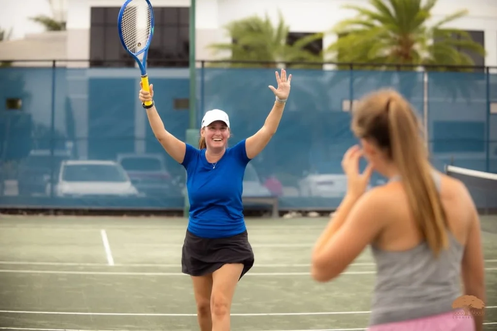 Members playing doubles tennis on Har-Tru clay courts at Boca Woods Country Club.