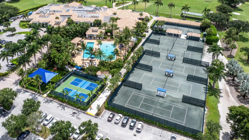 Aerial view of Bocaire Country Club showing six Har-Tru tennis courts, pickleball courts, clubhouse, pool, and championship golf course in Boca Raton