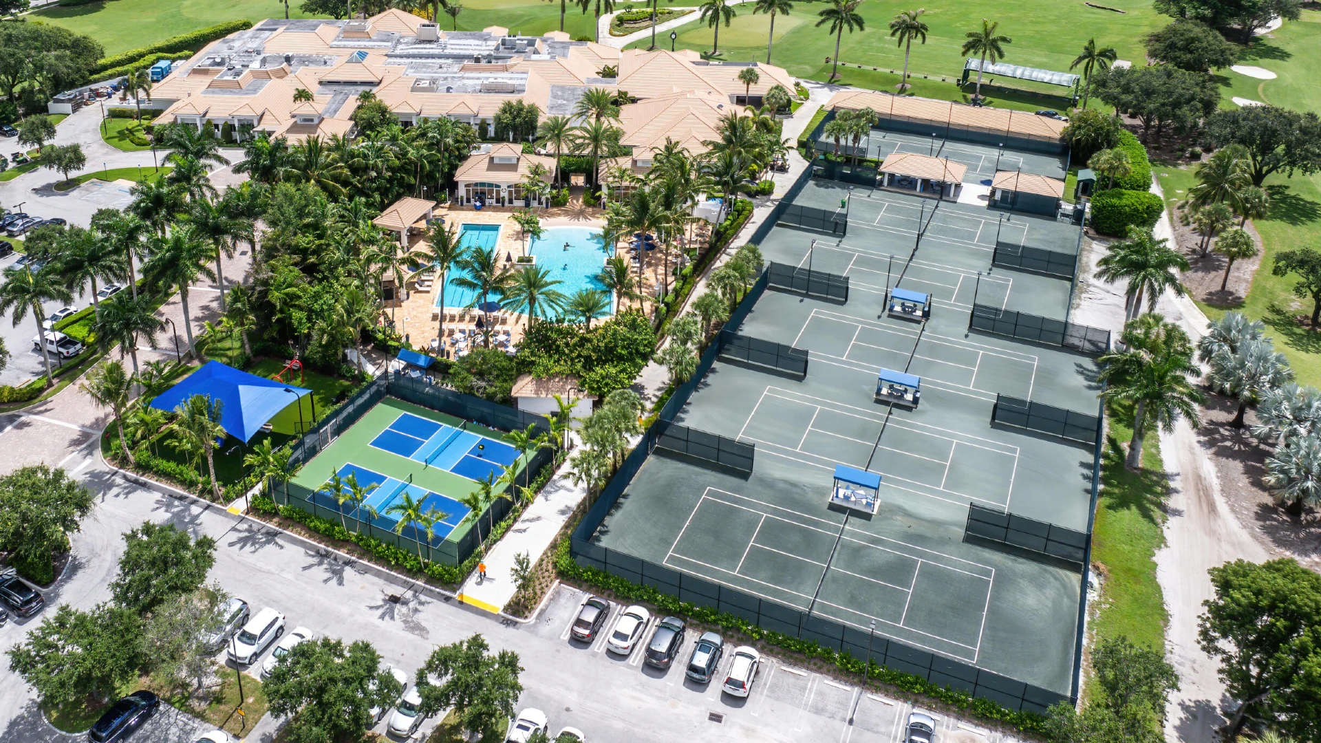 Aerial view of Bocaire Country Club showing six Har-Tru tennis courts, pickleball courts, clubhouse, pool, and championship golf course in Boca Raton