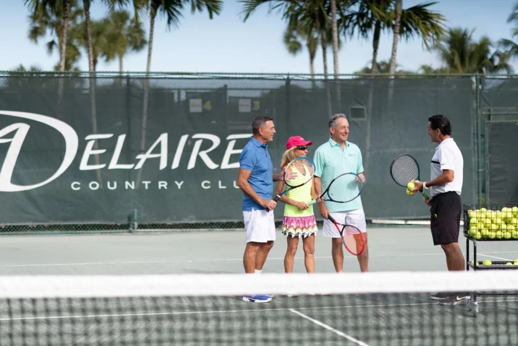 Members and pro at the net during a tennis clinic at Delaire Country Club