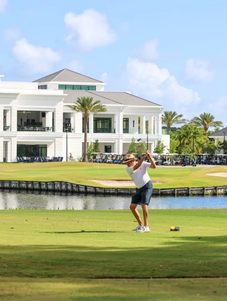Golfer playing on course with Frenchman's Creek clubhouse in background in Palm Beach Gardens Florida