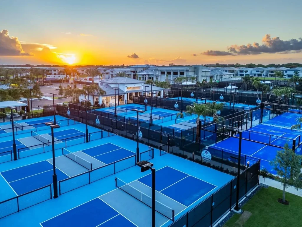 Aerial sunset view of Lotus Edge pickleball courts with clubhouse in background