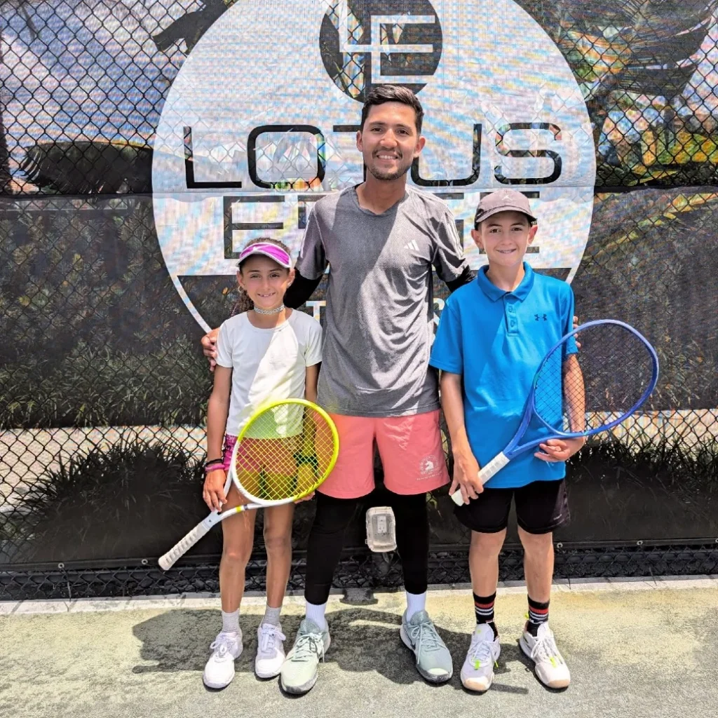 Tennis coach with two junior players at Lotus Edge courts in Boca Raton