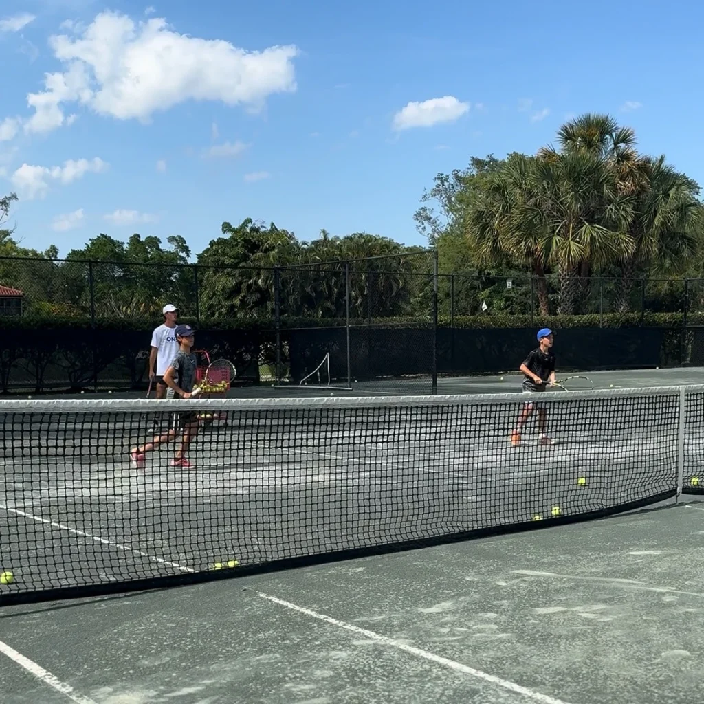 Junior tennis players training on clay courts at One Tennis Academy