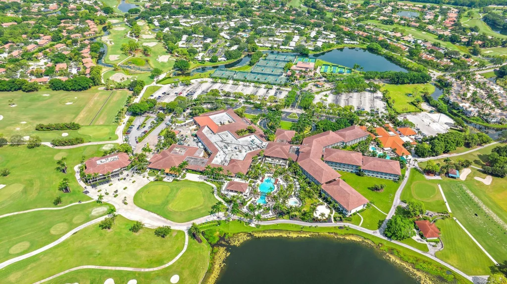 Aerial view of PGA National Resort showing the clubhouse, pool, golf courses, tennis courts, and pickleball courts in Palm Beach Gardens Florida