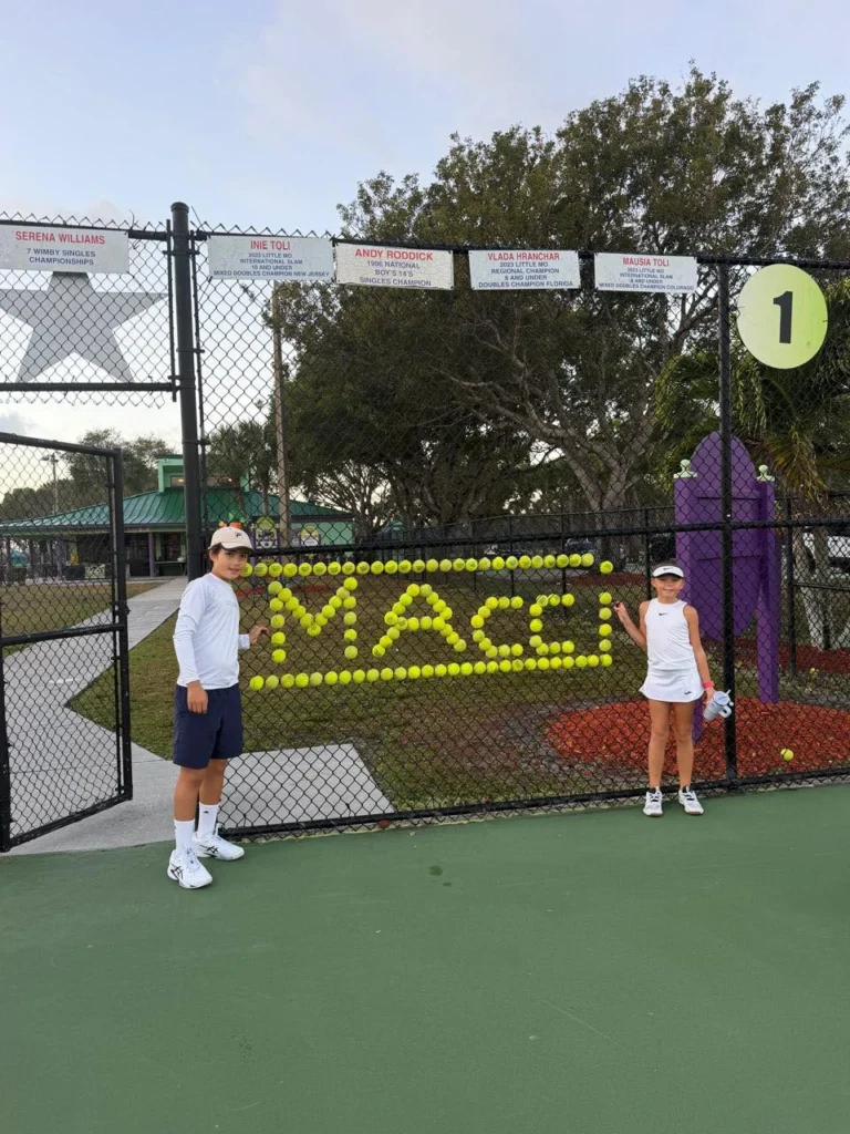 Junior players at Rick Macci Tennis Center with champion banners in Boca Raton