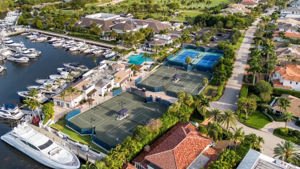 Aerial view of Royal Palm Yacht and Country Club showing tennis courts, marina, and waterway in Boca Raton