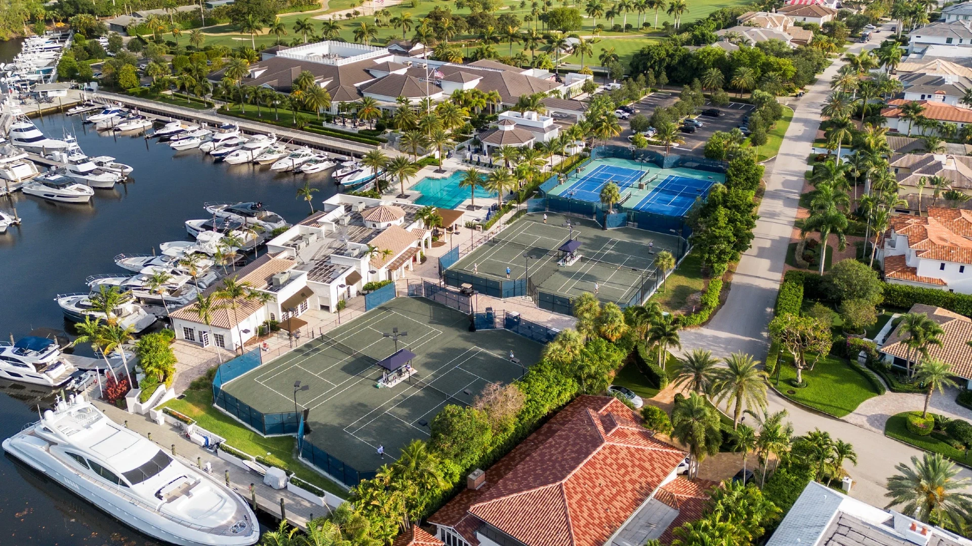 Aerial view of Royal Palm Yacht and Country Club showing tennis courts, marina, and waterway in Boca Raton