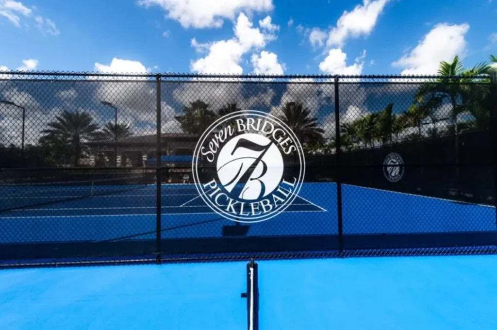 Seven Bridges Pickleball court with community branding on fence in Delray Beach