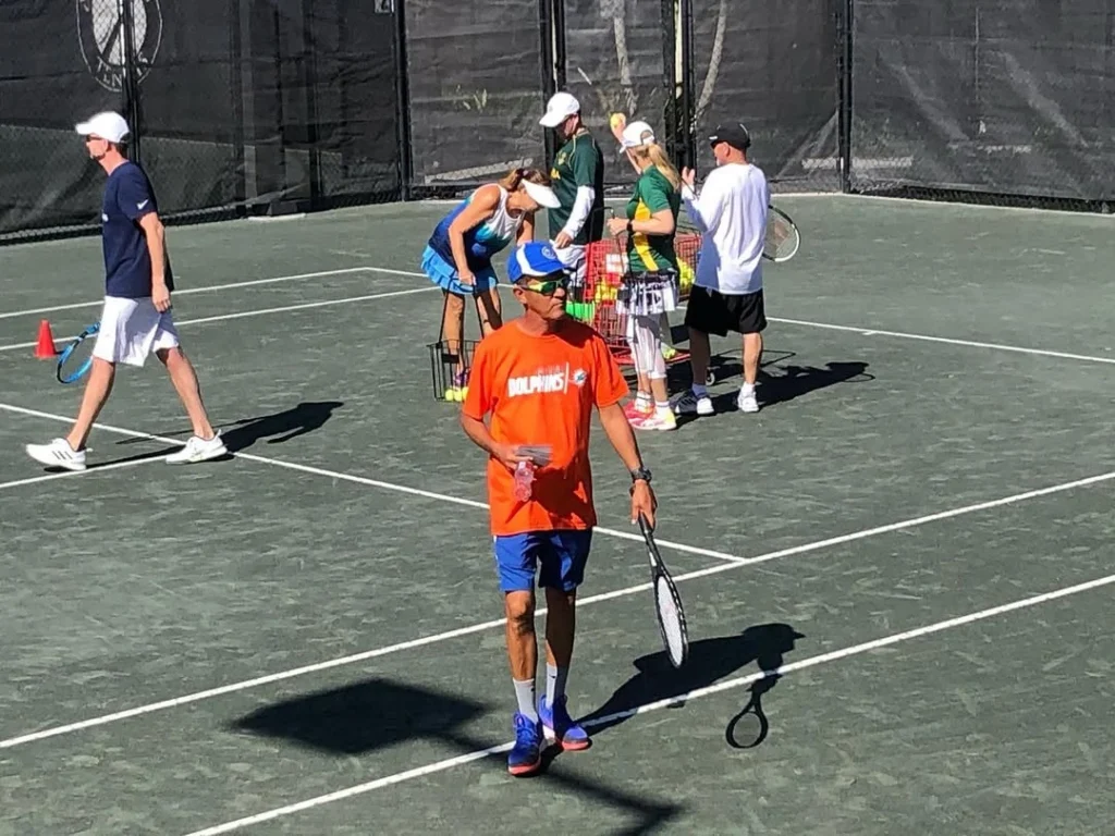 Mixed group tennis clinic session on Har-Tru courts at Seven Bridges Racquet Club