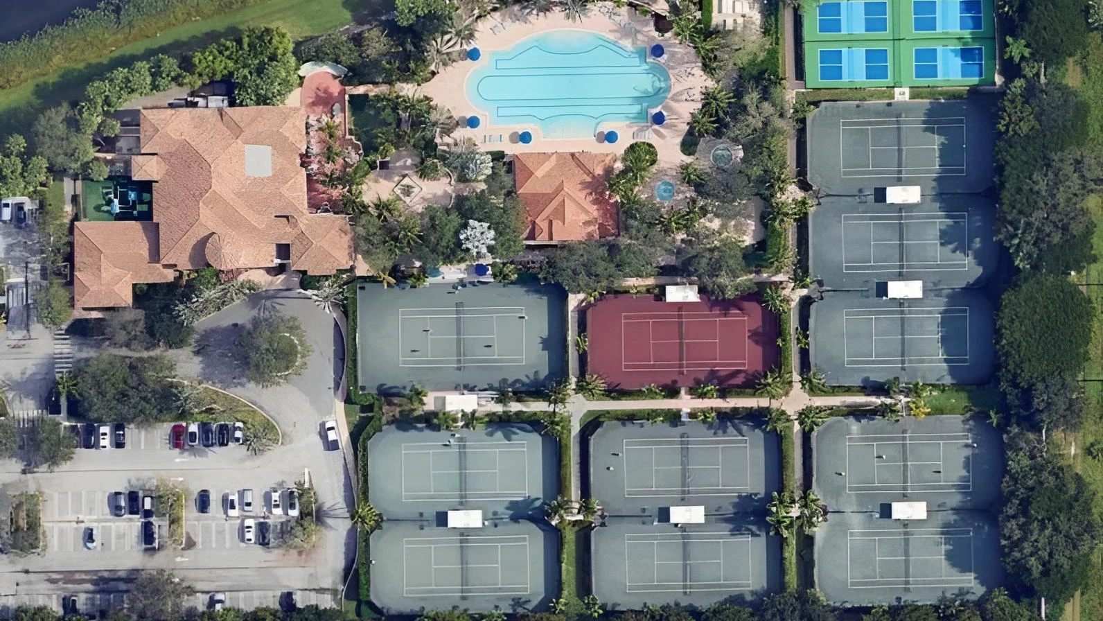 Aerial view of The Oaks Boca Raton racquet center featuring tennis courts, pickleball courts, clubhouse, and resort pool amenities