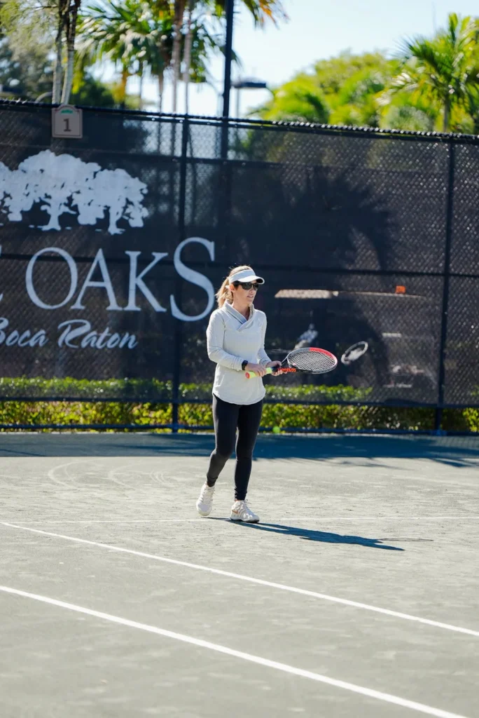 Resident playing tennis on a Hydro-Grid clay court at The Oaks Boca Raton