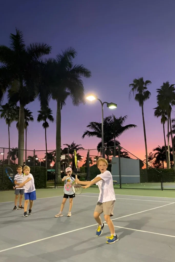 Junior tennis players training at sunset with White Lion Tennis School in Boca Raton