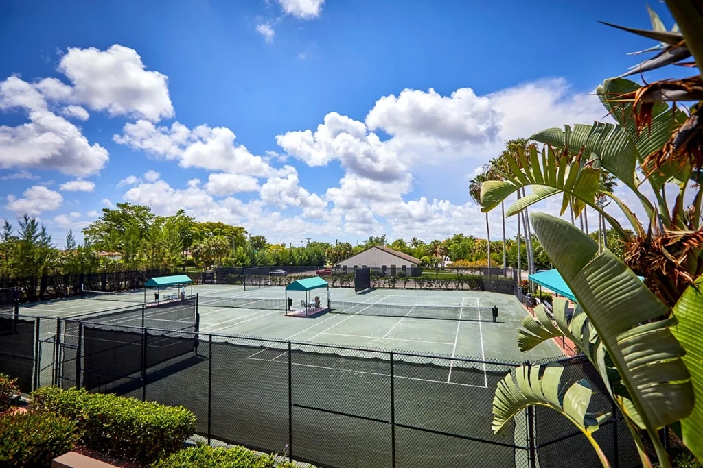 Aerial view of the Boca Lago Country Club Tennis Center with Har-Tru courts, pickleball courts, pool, clubhouse, and practice lawn.