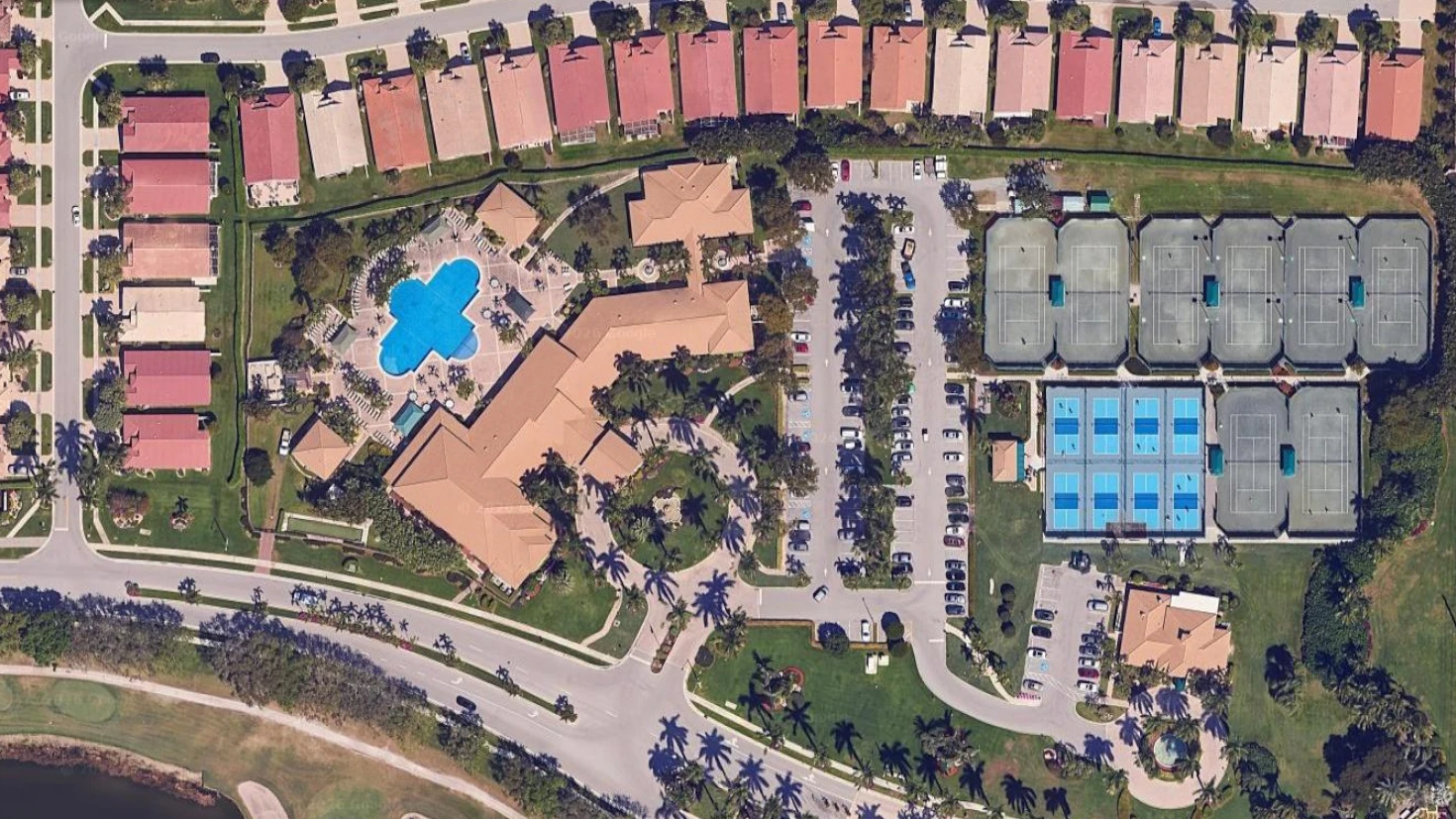 Aerial overview of The Cascades showing the clubhouse, resort pool, tennis courts, pickleball complex, and surrounding homes in Boynton Beach.