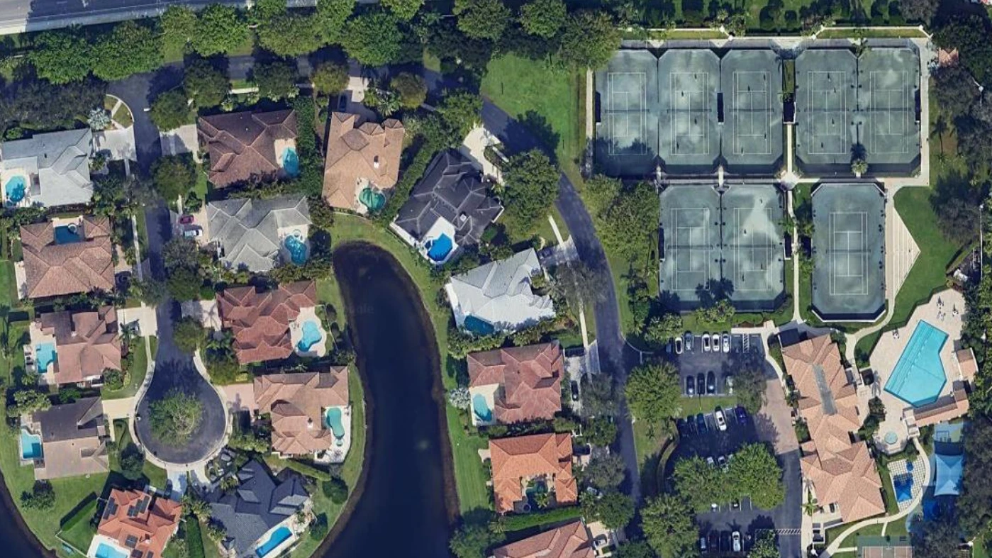 Aerial view of The Seasons in Boca Raton showing the tennis center, clubhouse, resort pool, and luxury homes.