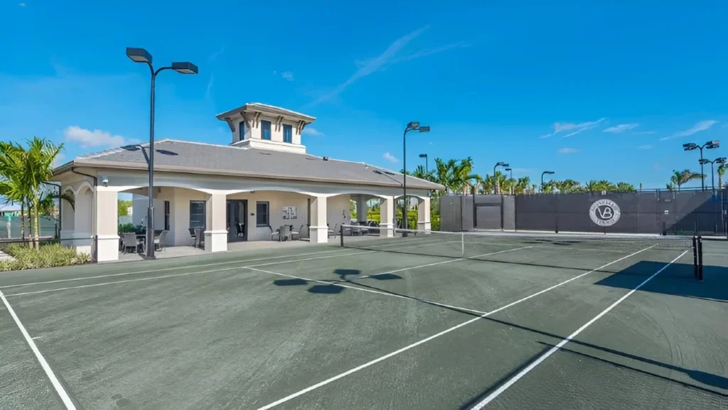 Har-Tru clay tennis courts at Valencia Bay with shaded pavilion and stadium lighting.