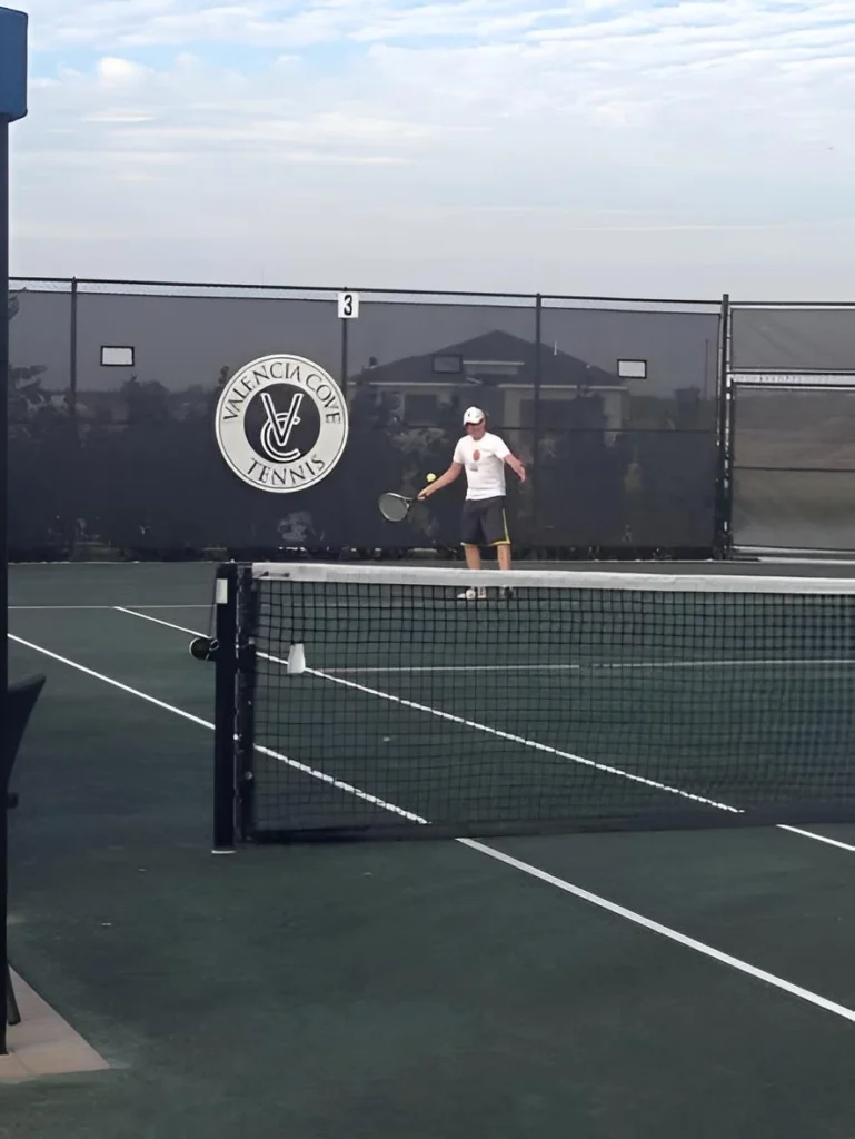 Resident playing tennis on a Har-Tru clay court at Valencia Cove in Boynton Beach