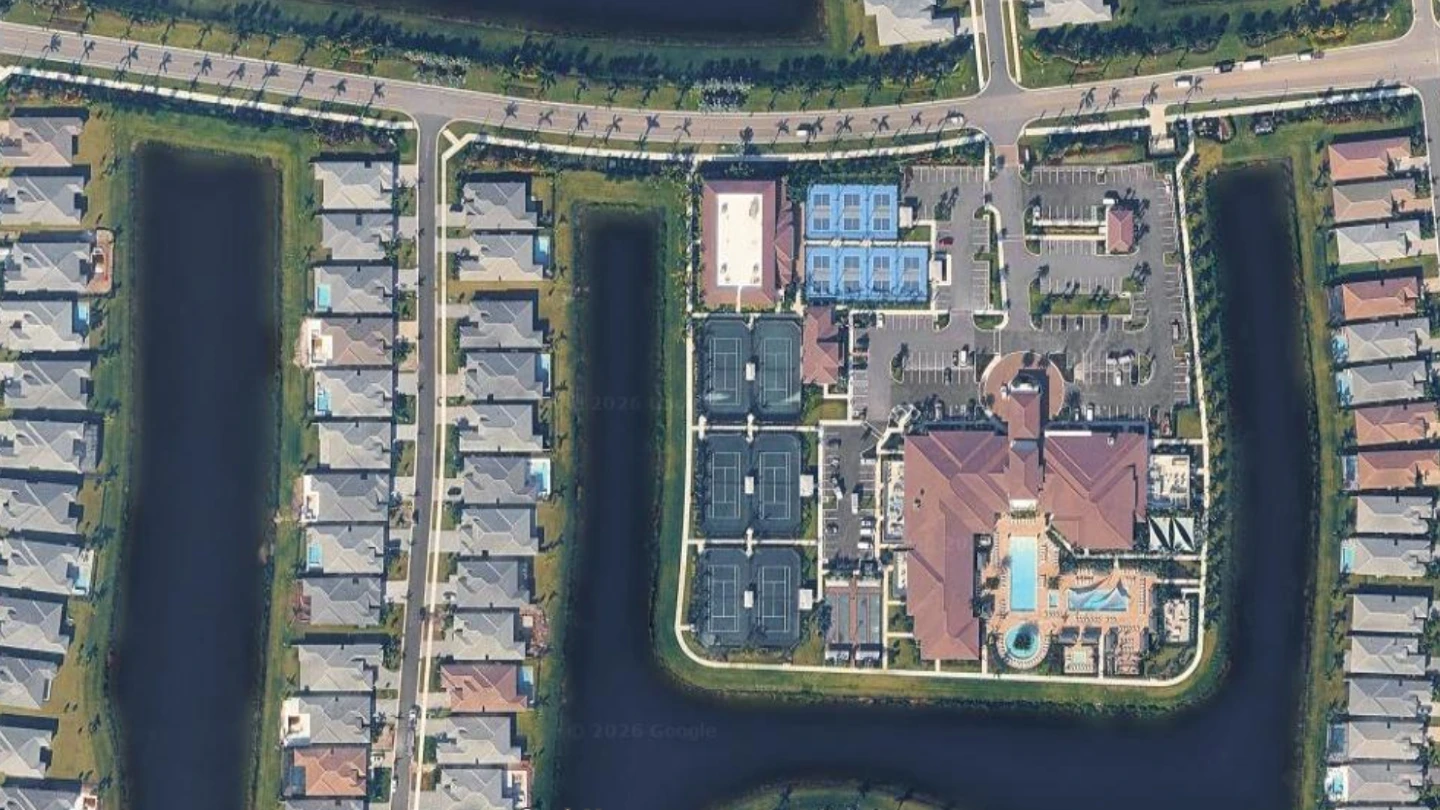 Aerial view of Valencia Grand in Boynton Beach showing the clubhouse, tennis courts, pickleball courts, and surrounding homes
