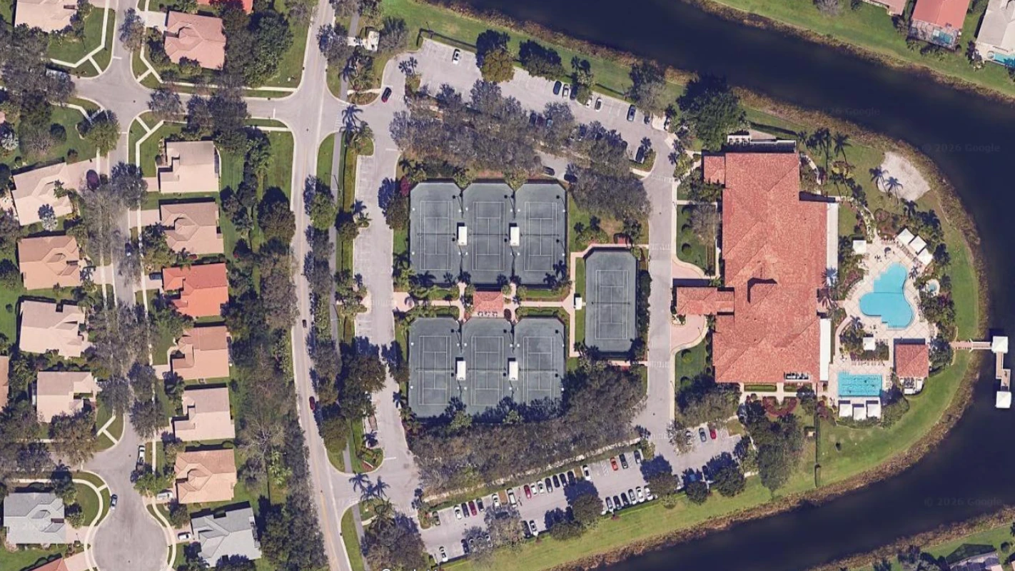 Aerial view of the Valencia Isles clubhouse, Har-Tru tennis courts, and lakefront amenities in Boynton Beach.