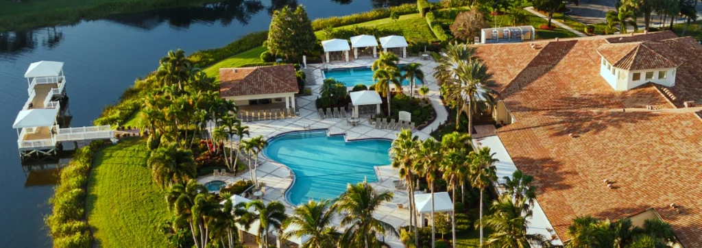 Resort-style clubhouse, swimming pools, and lakefront amenities at Valencia Isles in Boynton Beach.