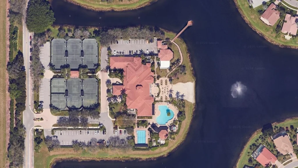 Aerial view of the Valencia Lakes clubhouse, Har-Tru tennis courts, pools, and lakefront setting in Boynton Beach.