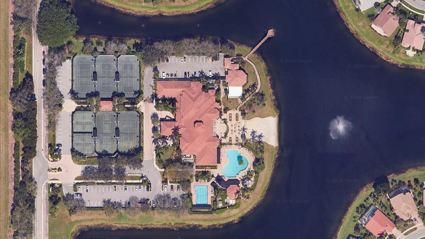 Aerial view of the Valencia Lakes clubhouse, Har-Tru tennis courts, pools, and lakefront setting in Boynton Beach.
